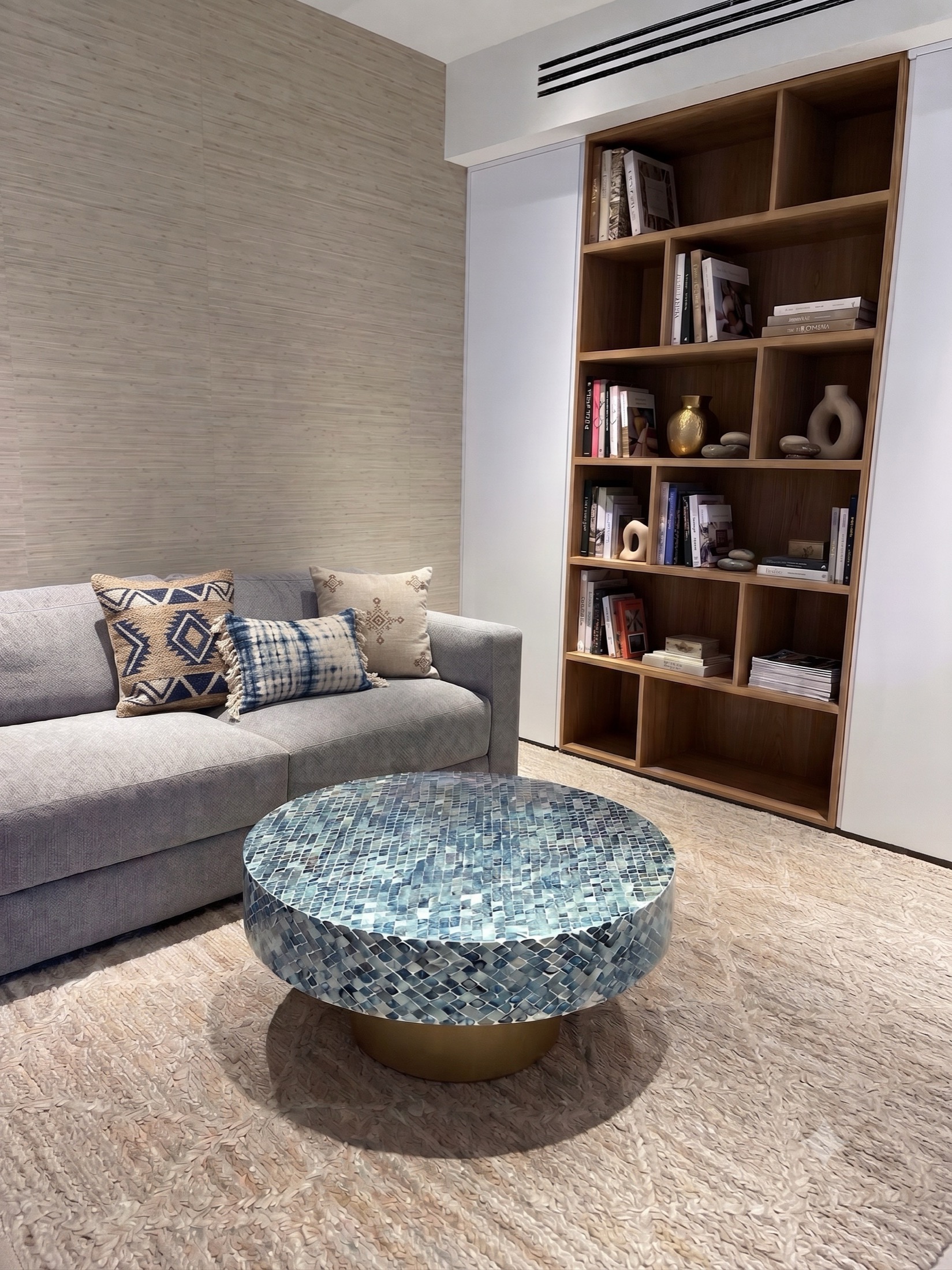 Living room with a round mosaic coffee table and a built-in bookshelf