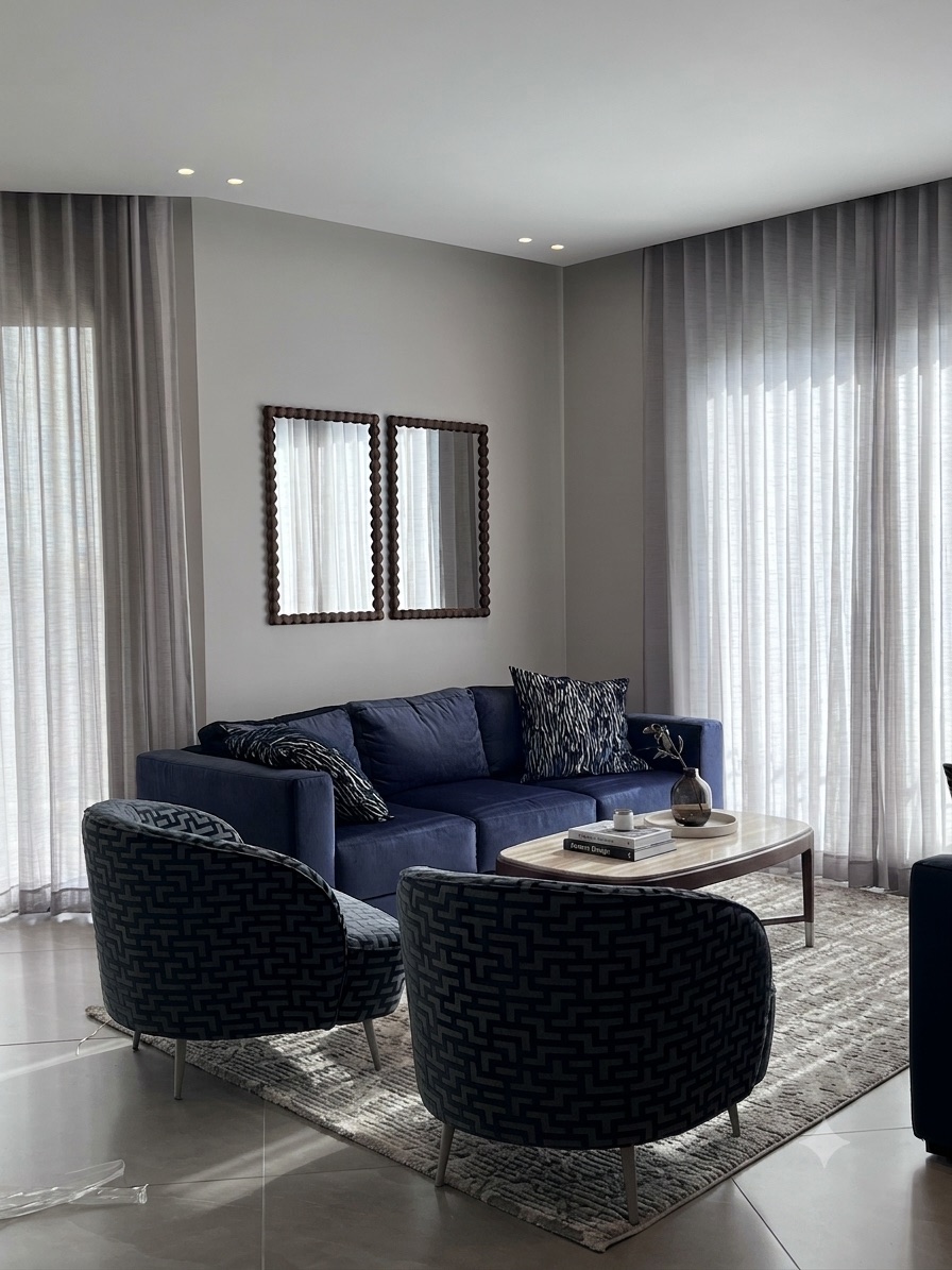 Living room with a navy velvet sofa and patterned swivel chairs