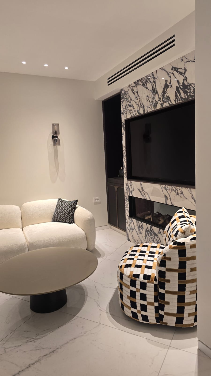 Living room with a marble fireplace surround and a cream curved sofa